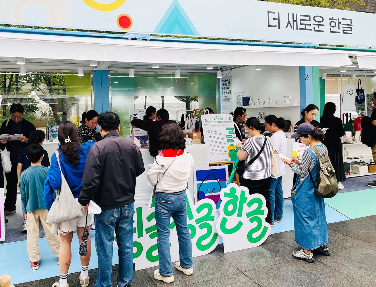‘2025 한글문화산업전’ 행사 현장 사진이다. ‘더 새로운 한글’이라는 문구가 적힌 전시 부스 앞에서 사람들이 줄을 서있다.