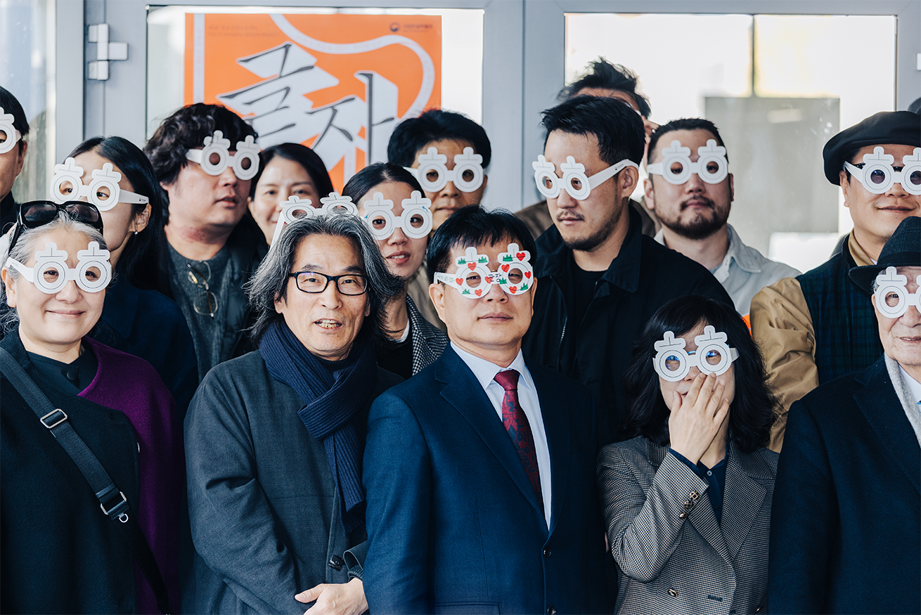 전시 개막식 현장에 참가한 사람들이 ‘히읗’이 그려진 종이 안경을 착용하고 기념사진을 찍고 있다.
