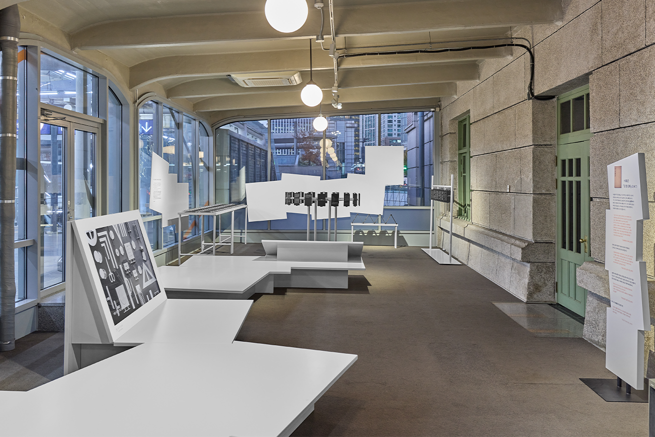 전시장 내부 사진이다. 종이를 접고 겹쳐서 만든 모양처럼 각이 진 구조물이 여러 방향으로 꺾이며 배치되어 있다.