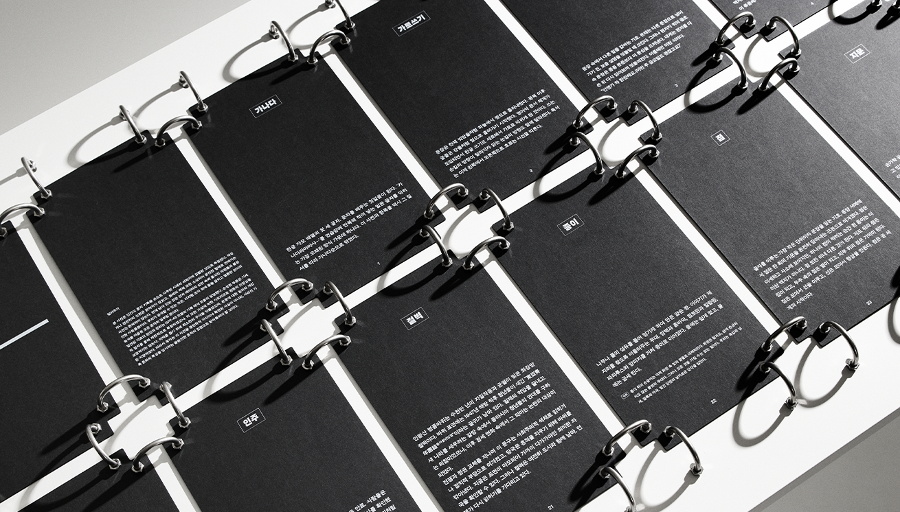 김영글 작가의 ‘흔적 사전’ 작품 사진이다. 검은 배경의 카드가 링 바인더에 정렬돼 있고, 각각의 카드에 흰 글씨로 글이 인쇄되어 있다.