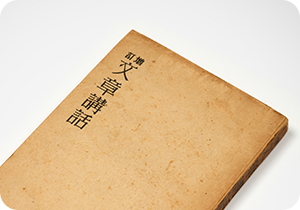 흰색 배경에 이태준의 ‘문장강화’ 소장품이 놓여있다. 책 표지는 연한 갈색빛을 띠며 세월의 흔적이 느껴진다. 표지 왼쪽 위에는 ‘문장강화’가 한자로 쓰여있다. 