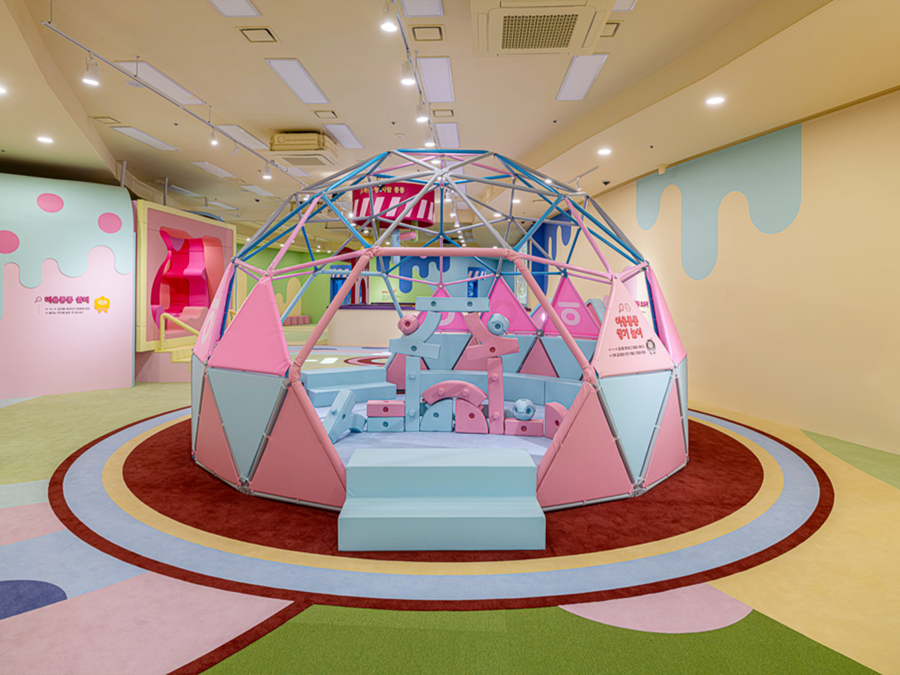 2부 ‘친구야! 한글놀이터에서 놀래?’ 내부 공간 사진이다. 아이들이 안에 들어가서 놀 수 있는 커다란 돔 형태의 정글짐 구조물이 세워져 있다. 