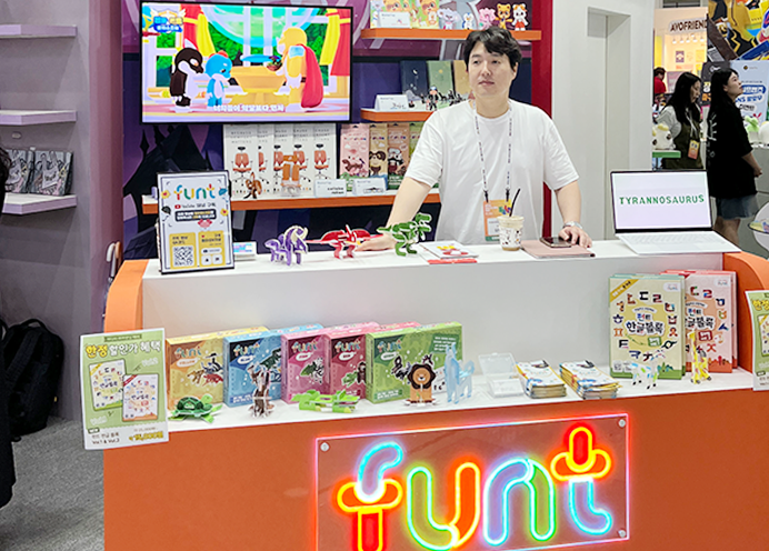‘펀트’라고 크게 적힌 진열대 안에 흰색 반팔을 입은 김형기 대표가 서있다. 김형기 대표 주변에는 아토이에서 나온 한글글자블록 상품이 나란히 진열되어 있다.