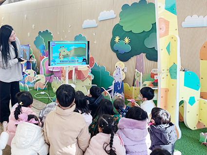 아이들 여러 명이 바닥에 앉아 모니터를 바라보며 선생님의 설명을 듣고 있다. 