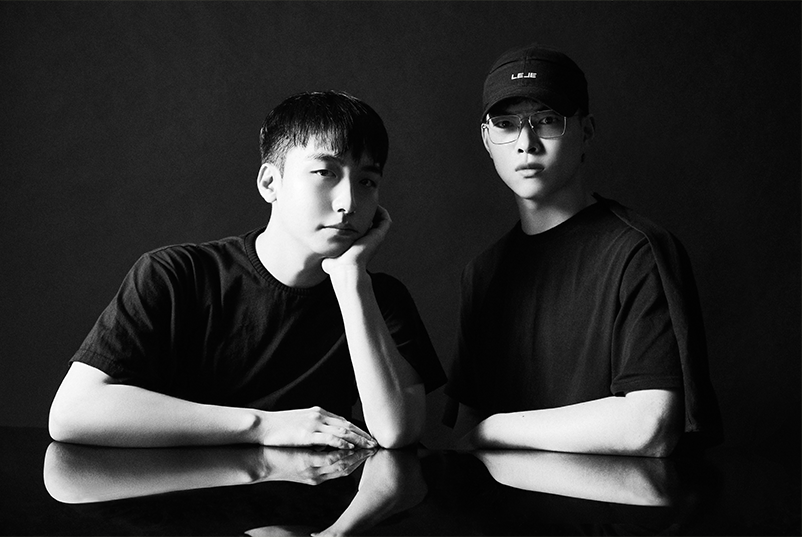 어두운 배경 앞에서 르쥬의 강주형, 제양모 디자이너가 나란히 앉아 있다. 