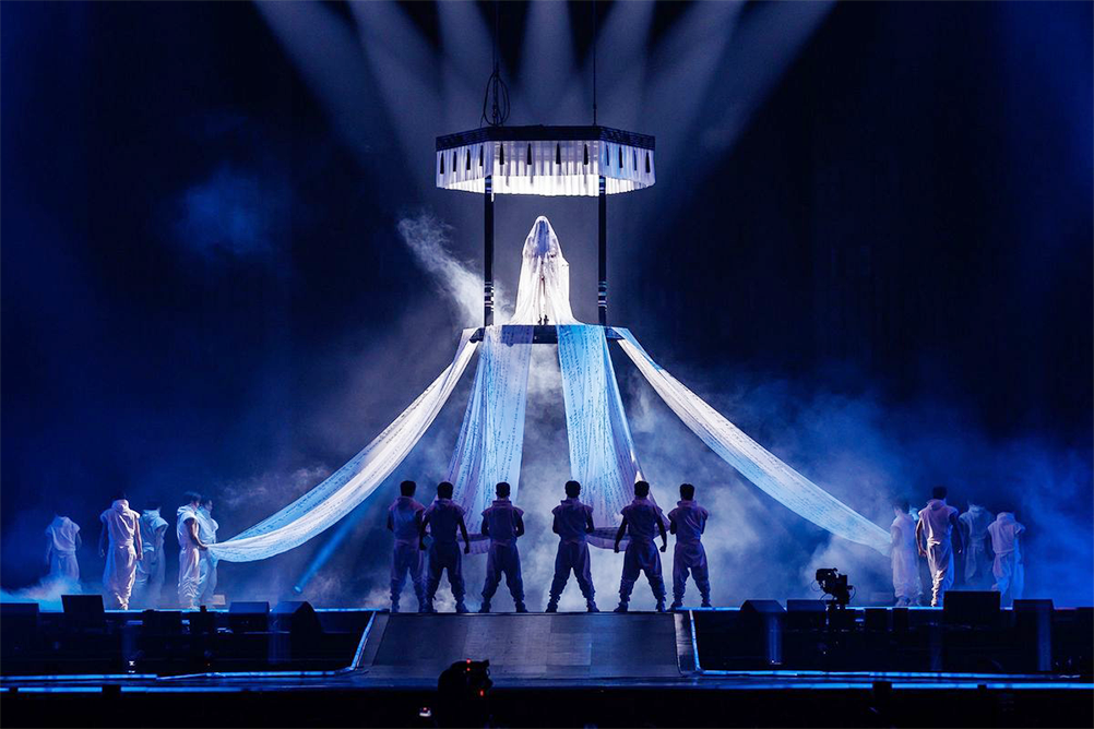 2025 MMA 블랙핑크 제니의 무대 사진이다. 넓은 무대 중앙에 높은 구조물이 세워져 있고, 그 위에 ‘청구영언’이 새겨진 15미터 길이의 베일을 입은 제니가 서 있다.