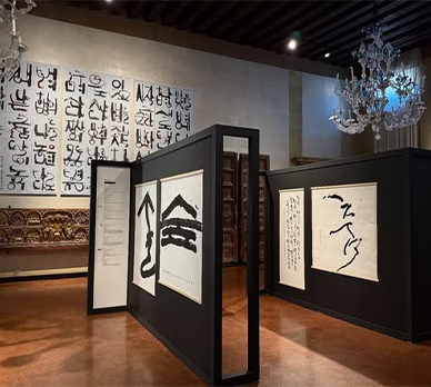 액자와 병풍 형태로 전시된 서예 작품들이 조명 아래 놓여있다.