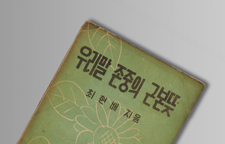 외솔 최현배 선생이 쓴 『우리말 존중의 근본뜻』 책 표지 사진이다. 초록색 바탕에 흰색으로 꽃과 나뭇잎이 그려져 있다. 