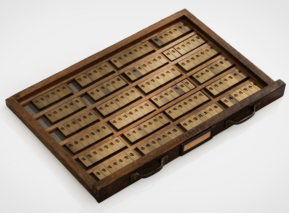 근대 황판 인쇄 관련 유물 사진이다. 나무로 만든 직사각형 상자 안에 여러 개의 얇은 금속판이 가지런히 배열되어 있다. 