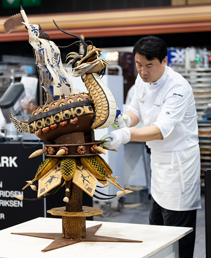 거북선 빵을 만들고 있는 최용환 셰프 사진이다. 작업대 위에 놓인 거북선 빵을 정성스럽게 다듬고 있다.