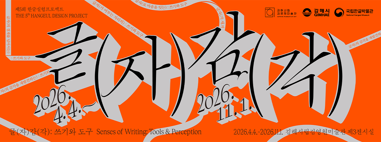 전시 ‘글(자)감(각): 쓰기와 도구’ 포스터 사진이다. 강렬한 주황색 배경 위에 ‘글자감각’이라는 한글 타이포그래피가 크게 배치되어 있다. 붓글씨처럼 거칠고 역동적인 획으로 표현된 글자가 화면을 가득 채운다. 글자 주변에는 ‘2026.4.4.’, ‘2026.11.1.’ 등의 전시 기간 정보가 함께 보인다.