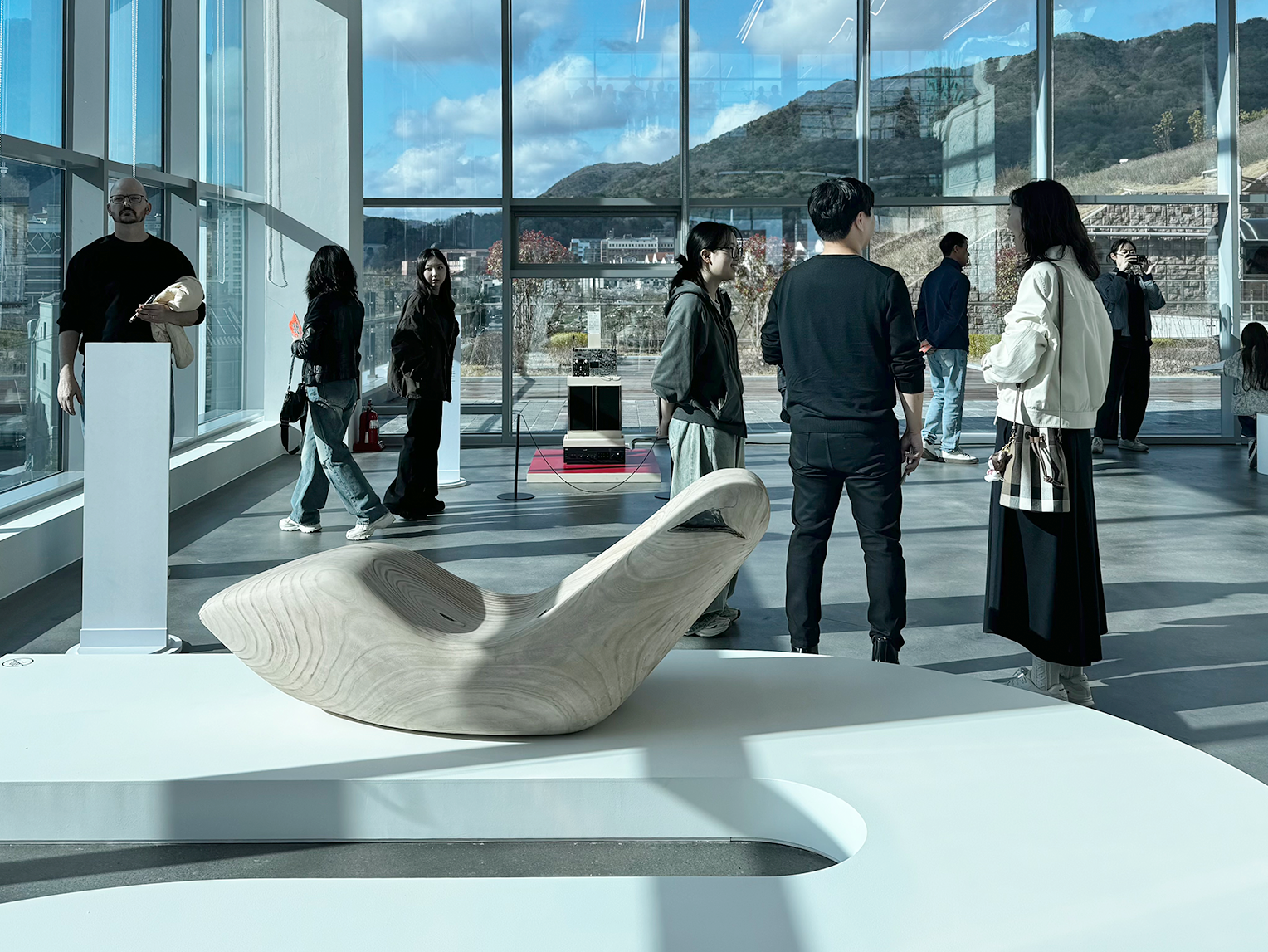 <글(자)감(각): 쓰기와 도구> 김해 순회전 현장 사진이다. 넓은 전시실 중앙에 설치된 조형 작품 주변으로 관람객들이 둘러서 있다.