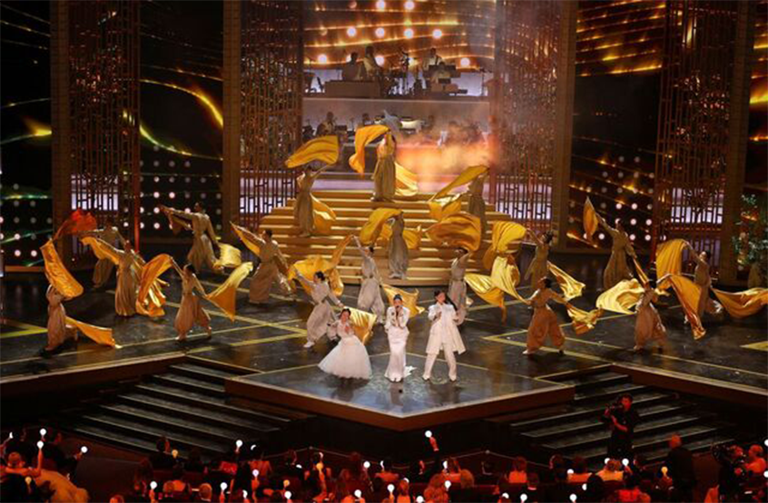 제98회 아카데미 시상식에서 펼쳐진 ‘케이팝 데몬 헌터스’ 축하 무대 사진이다. 이재, 오드리 누나, 레이 아미가 무대 위에서 ‘골든’을 열창하고 있다.