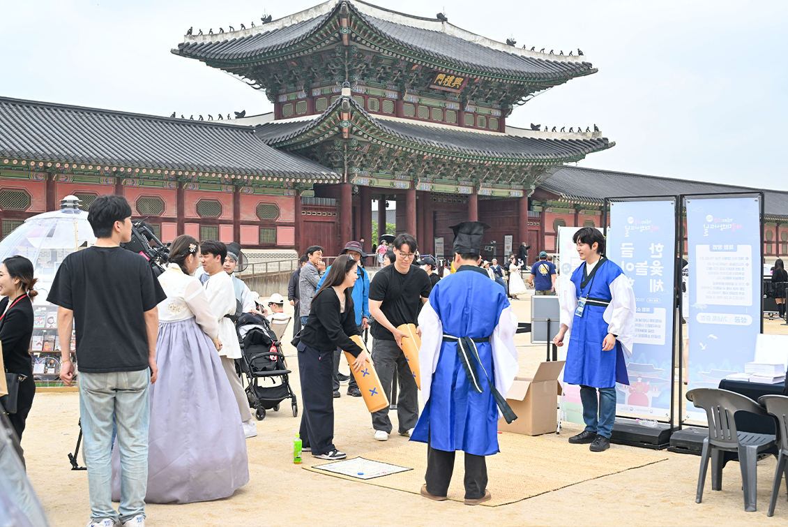 2025년 ‘제628돌 세종대왕 나신 날’ 기념 행사 사진이다. 전통 한복을 입은 진행자와 시민들이 마주 서서 설명을 듣거나 체험에 참여하고 있다.