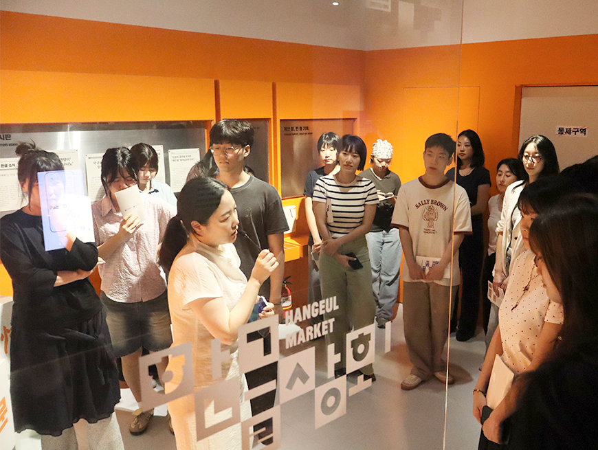 전시 연계 워크숍 ‘글놀이 말놀이 그리고 활자놀이’ 현장. 참가자들이 학예사의 전시 설명을 듣고 있다.