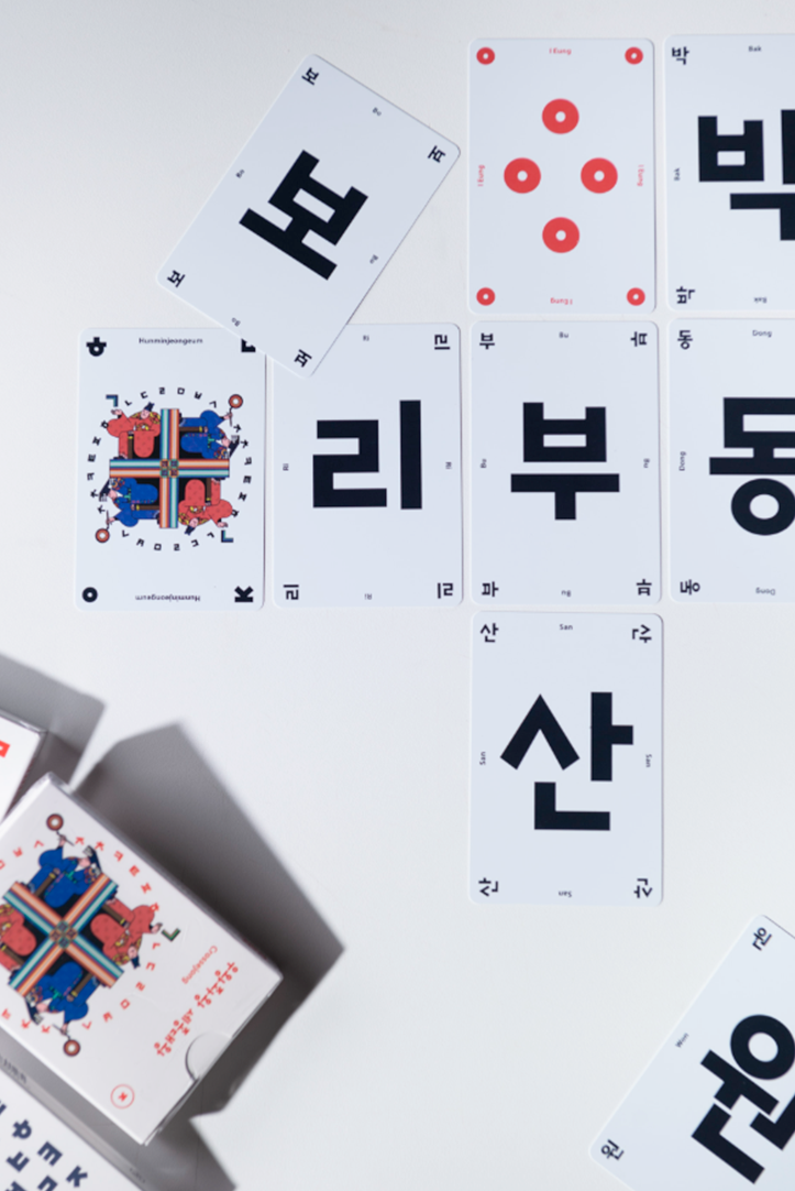 한글 글자와 붉은 원형 무늬가 인쇄된 대형 카드들이 격자 형태로 놓여 있으며, 옆에는 ‘우왕좌왕 세종대왕’ 카드 묶음이 배치되어 있다.