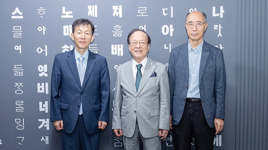 임성환 국립한글박물관장, 최홍식 세종대왕기념사업회장, 김주원 한글학회장이 훈민정음이 적힌 벽을 배경으로 나란히 서서 기념사진을 촬영하고 있다.
                                                                                     