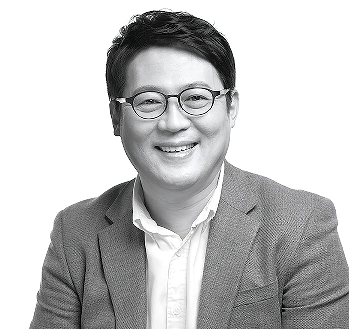 김경일 교수의 흑백 사진. 정장을 입고 안경을 착용한 김경일 교수가 환하게 웃고 있다. 